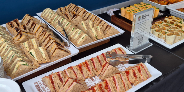 A selection of sandwiches and finger buffet items on a catering station.