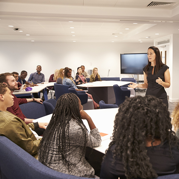 Female teacher addressing group of students