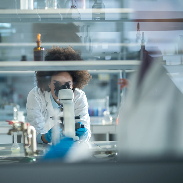 Scientist at microscope in laboratory