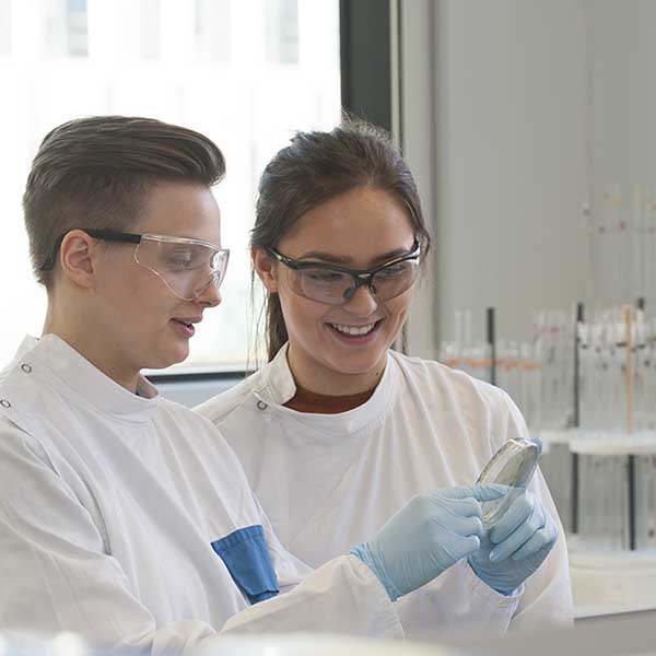 Students examining petri dish in lab