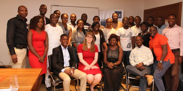 a group of Nigerian Strathclyde Alumni stand together for a group photo, smiling at the camera