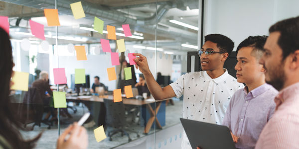 Decorative: People looking at sticky notes on a wall