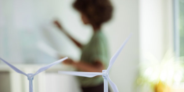 Decorative: A woman standing near a model of a windfarm