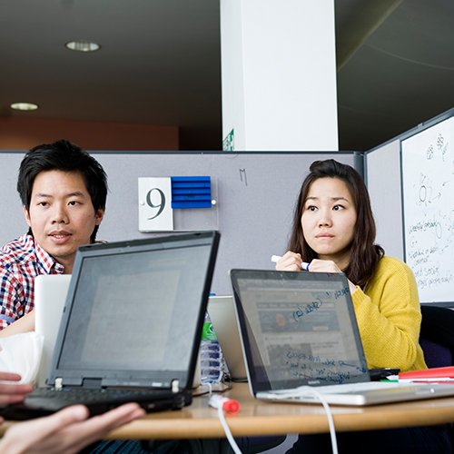 Students round a table doing group work