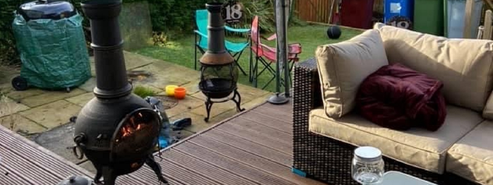 A garden with decking, furniture, and a chimnea