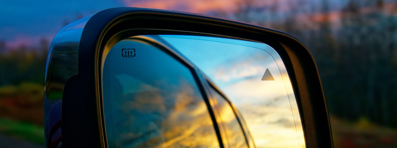 Reflection of landscape in a car wing mirror