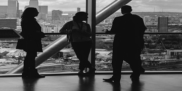 Black & white photo of people standing at a large window