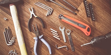 A selection of hand tools spread out across a workbench