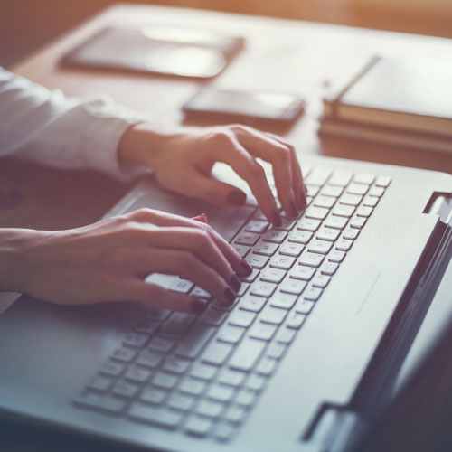 a woman typing on a laptop