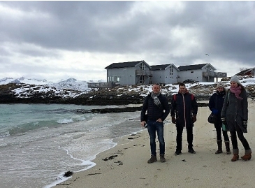 A group photo of Svein, John and 2 others on a windswept beach in Norway.