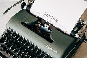 A typewriter with a sheet of paper with the word 'Review' typed on it