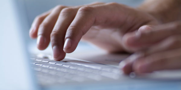 a man types on a laptop keyboard