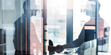 two businessmen shaking hands in an office