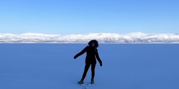 Silhouette of person in front of snowy mountains