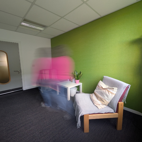 Consulting room with blurred figure moving across it