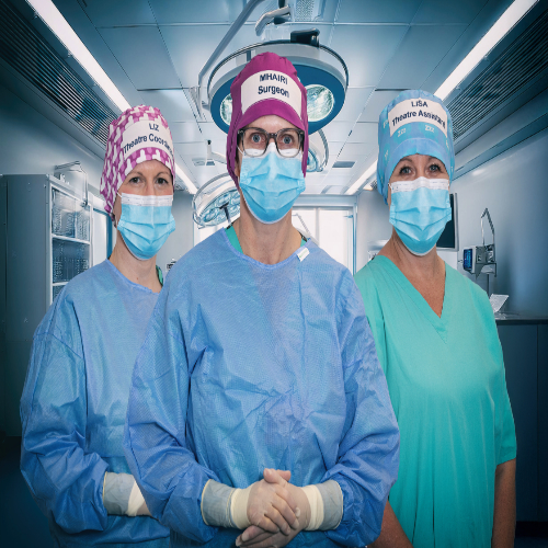 three people dressed in theatre scrubs with caps on