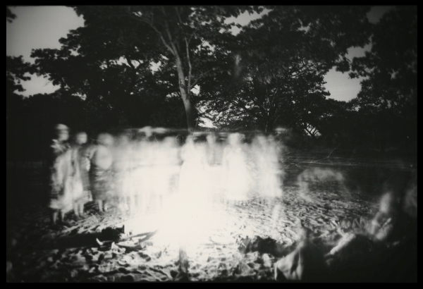 Black and white tree with ghostly white blurred figures