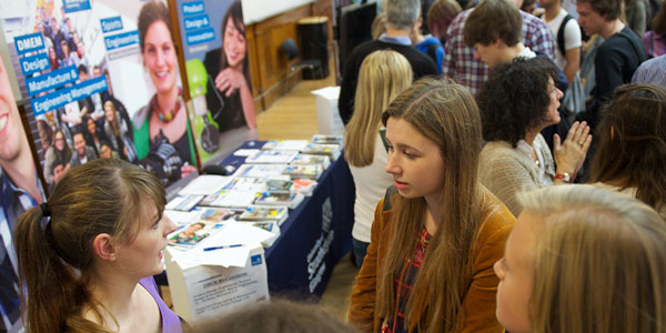 female applicant talks to a member of staff at a stand at an open day event