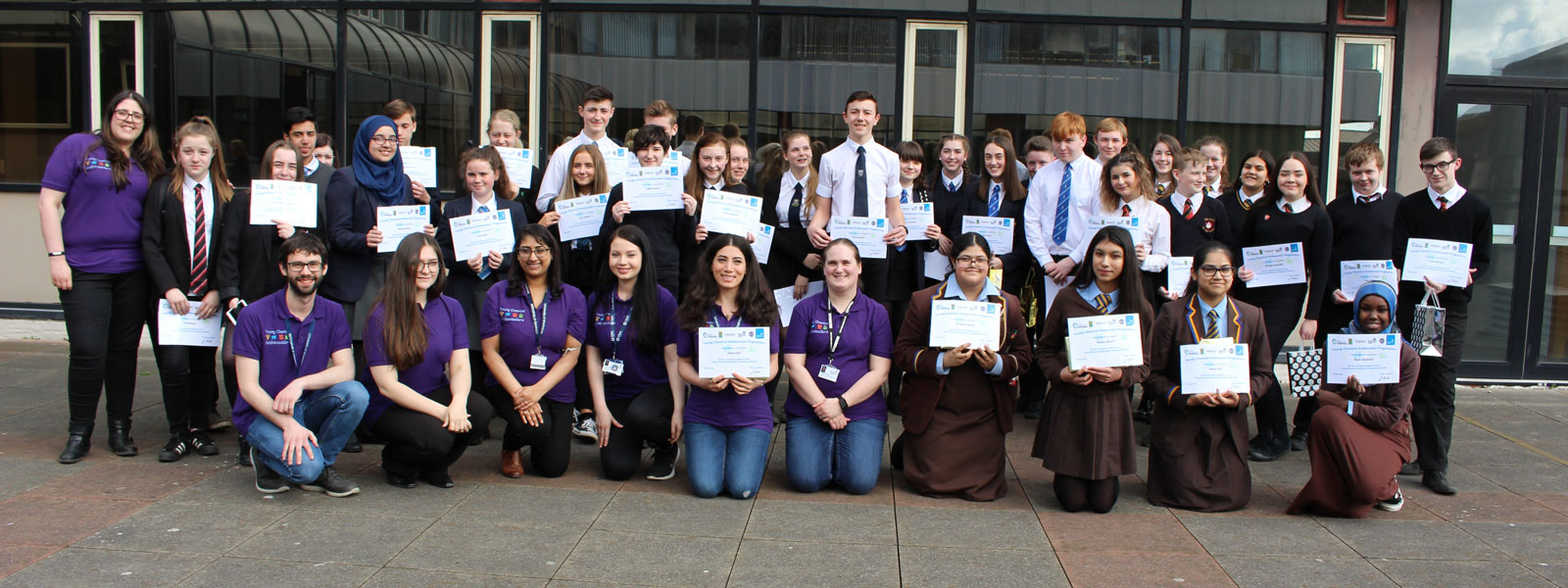 Young Chemical Ambassadors participants hold their certificates and smile for the camera