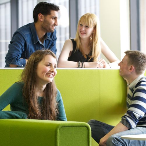 Four students sitting laughing with each other