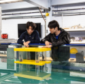 Two students observing a water tank Two students observing a water tank