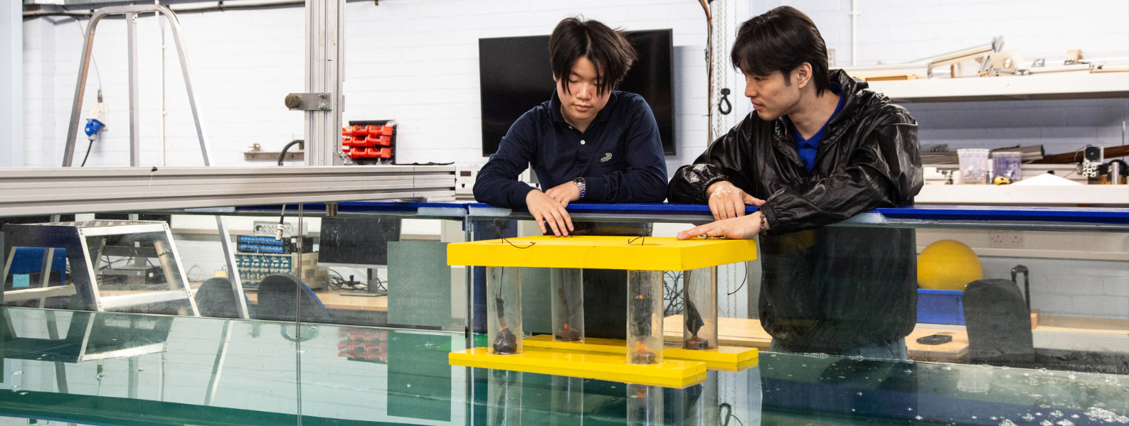 Two students observing a water tank
