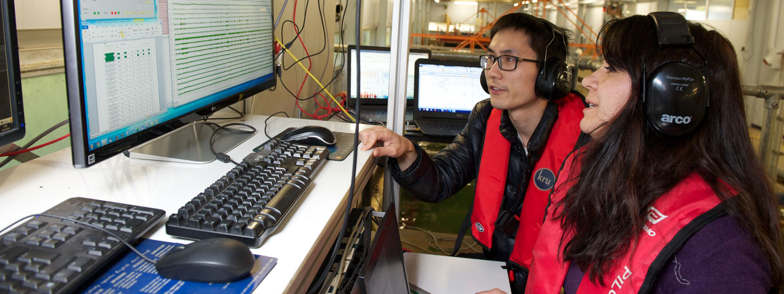 close up of students analysing data on a computer, stationed on the platform over a water tank