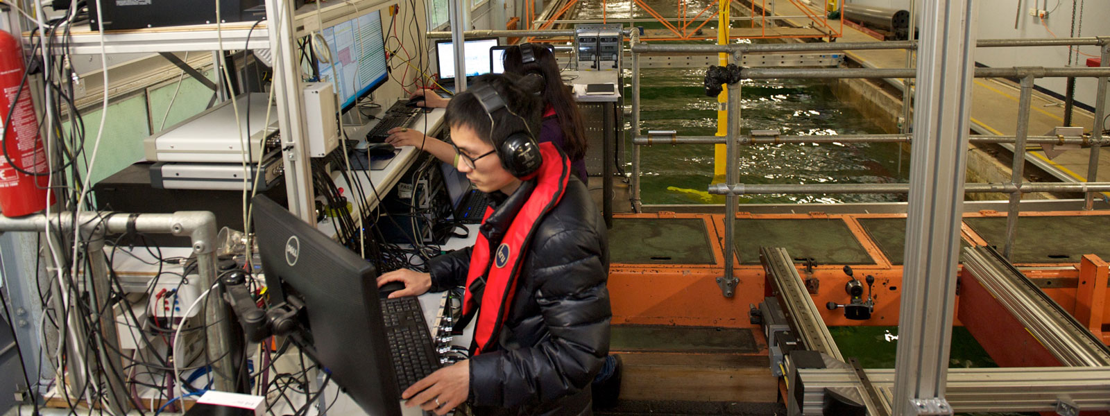 students analyse data on a computer on a platform over the water tank