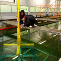Two research students fixing a large yellow pole in the water