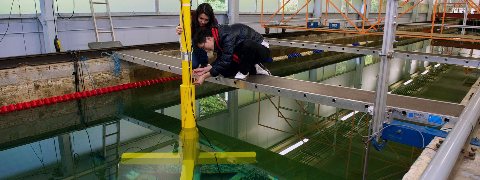 two research students fixing a yellow pole in the water