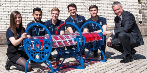 Gemma Houston and team kneeling in front of their 'roll over bench' creation