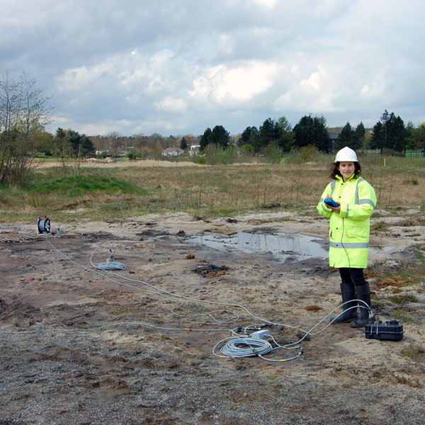 engineering Stella Pytharouli wearing a hard hat and a high vis jacket working out in the field 