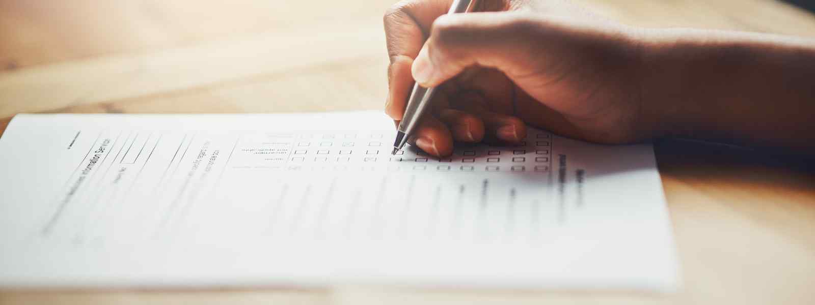 hand holding a pen writing on paper hand holding a pen writing on paper