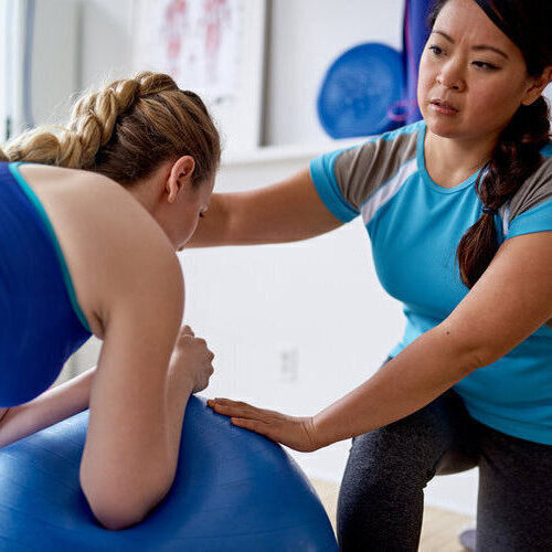 Personal trainer assisting client during treatment