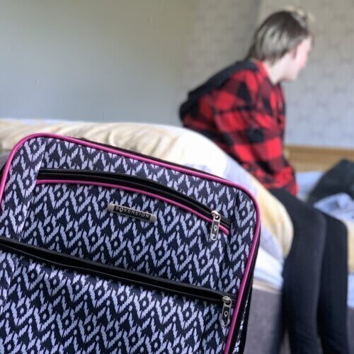 Girl sitting on bed with close up shot of bag