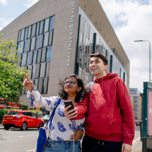 Two students walking outside the TIC Building