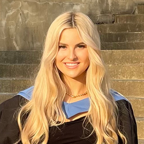 A blonde haired young woman in a graduation gown