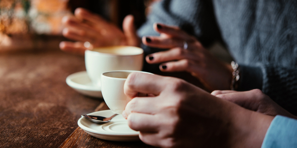 Two people talking over coffee