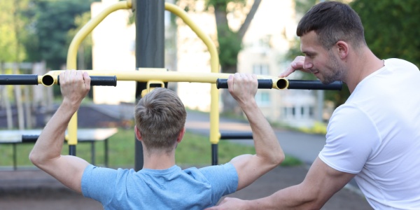 young man outside with personal trainer