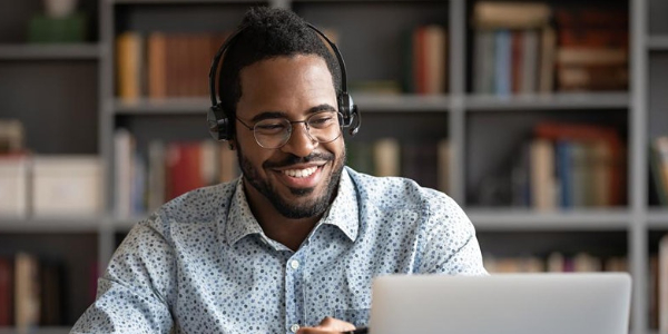 A man wearing headphones in front of a laptop A man wearing headphones in front of a laptop