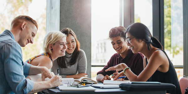 Students round a table chatting