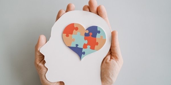 Hands holding jigsaw puzzle heart shape in brain Autism awareness, neurodiversity concept, World Autism Awareness Day