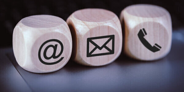 Contact Methods. Close-up of a phone, email and post icons wooden block