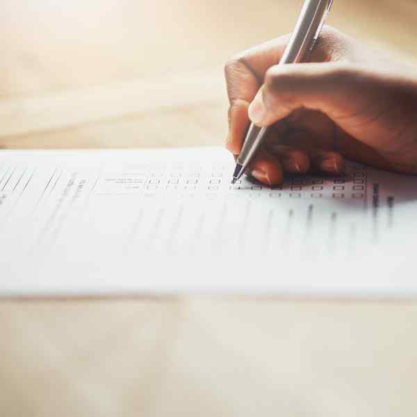 hand holding a pen writing on paper