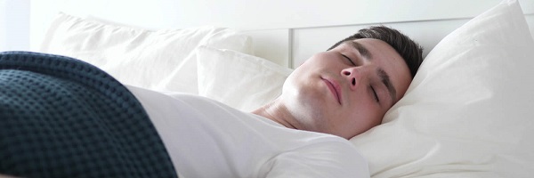 Young man sleeping on a white pillow