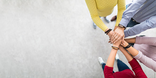 Colleagues stack their hands