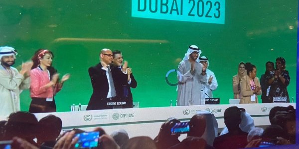 People clapping onstage with DUBAI 2023 in the background