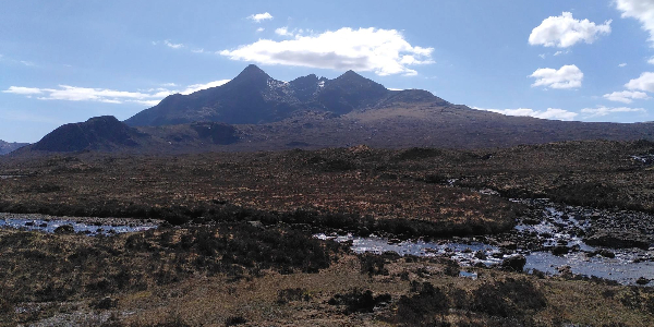 Mountains on the Isle of Skye on a sunny day, river in foreground