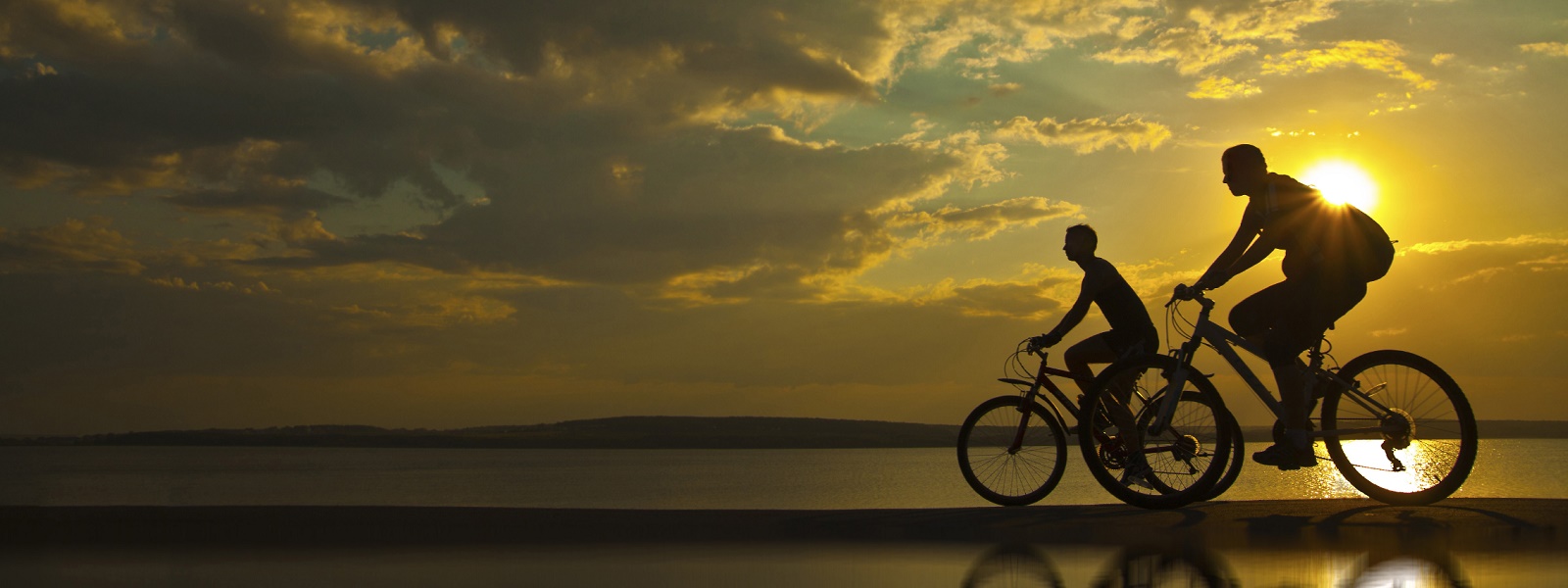 couple cycling in the sunset