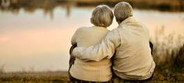elderly couple sitting at a lake